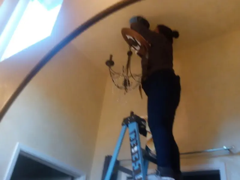 Electrician installing a chandelier in a Cheney residence